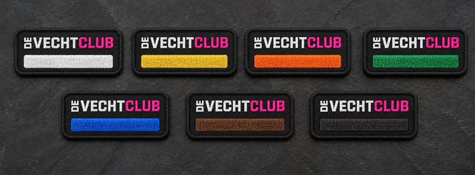 Seven embroidered De Vechtclub tags with stripes in white, yellow, orange, green, blue, brown, and black