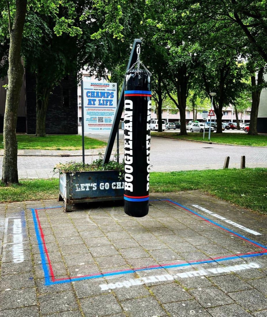 The Bokszak Weesp punching bag on its post in Sinnigvelderplantsoen, with the outline marked on the paving stones